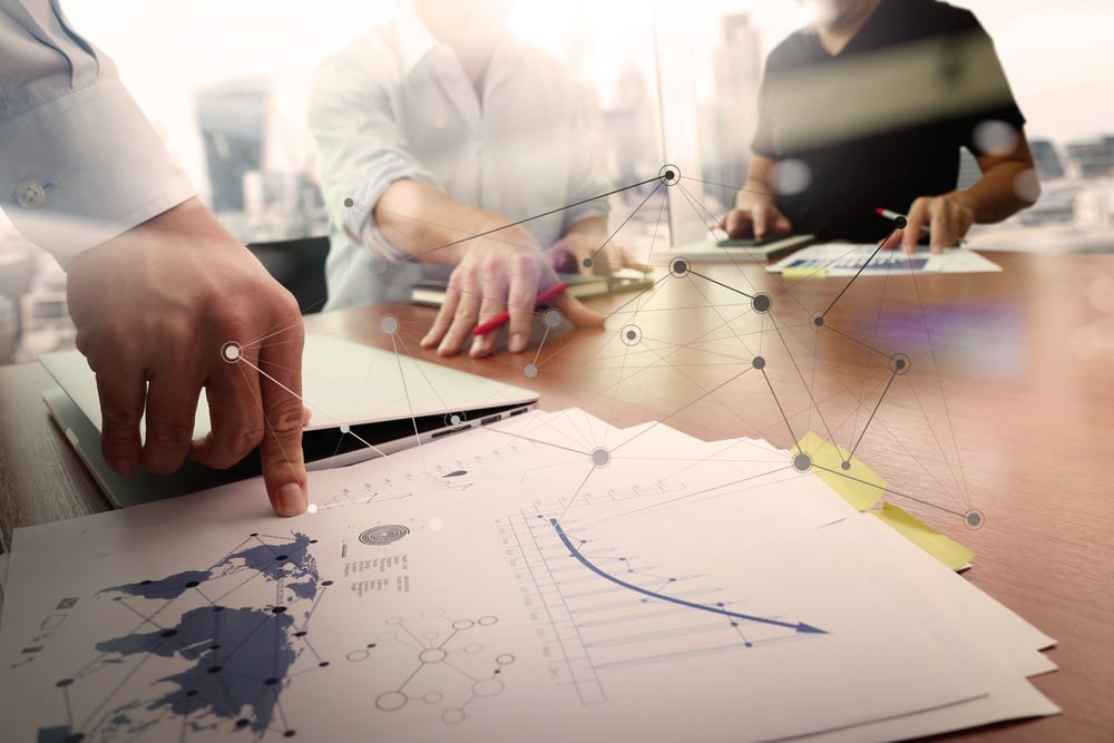 People in a business strategy meeting with documents around a table